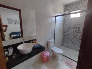 W łazience znajduje się umywalka, toaleta i lustro. w obiekcie Lar das Cerejeiras w mieście Bananeiras