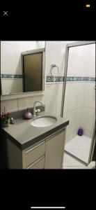 La salle de bains est pourvue d'un lavabo et d'un miroir. dans l'établissement Casa em Zimbros - DISPONÍVEL CARNAVAL, à Bombinhas