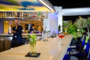 un bar con una mesa larga con bebidas. en Poli House by AFI Hotels, en Tel Aviv