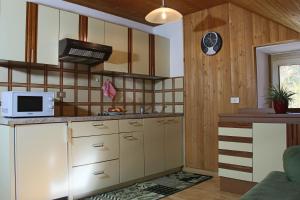 a kitchen with white cabinets and a microwave at Ciasa Alfri in La Villa