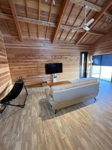 een woonkamer met een bank en een flatscreen-tv bij Blu Pointe in Minamiboso