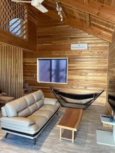 een woonkamer met een bank en een hangmat bij Blu Pointe in Minamiboso