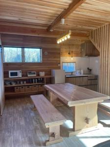 een grote houten keuken met een houten tafel en een bank bij Blu Pointe in Minamiboso