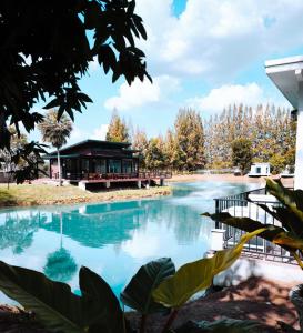una piscina d'acqua con un edificio sullo sfondo di Skybird lake view Resort&Camping Khaoyai a Khanong Phra