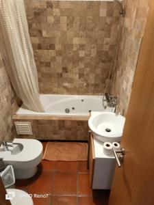 a bathroom with a tub and a toilet and a sink at Residencial Monte Gordo Golf Rei Algarve in Monte Gordo