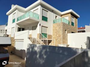 Residencial Monte Gordo Golf Rei Algarve في مونت غوردو: منزل أبيض مع شرفة فوقه