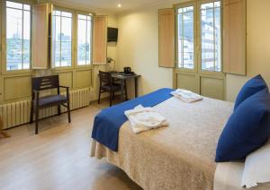 a room with a bed with towels on it at Hotel Roma in Sarria