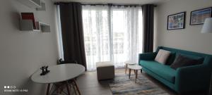 sala de estar con sofá verde y mesa en Departamento nuevo y cómodo en Santiago