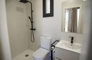 W łazience znajduje się toaleta, umywalka i lustro. w obiekcie Apartamentos Miramundos w mieście Albanchez de Úbeda