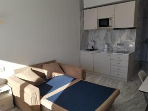 uma sala de estar com um sofá e uma cozinha em Segreto apartment 309, 311, 341 em Gudauri