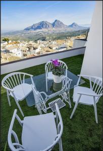 grupa krzeseł i stół na balkonie w obiekcie Apartamentos Miramundos w mieście Albanchez de Úbeda