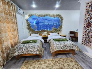 two beds in a room with a mural on the wall at Samani Bukhara in Bukhara