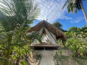 une petite tente avec une table et un palmier dans l'établissement Harmony Healing Project - Connect With Your Divinity, à El Nido