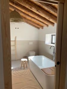 een badkamer met een bad, een toilet en een kruk bij Finca Las Botas in Almansa