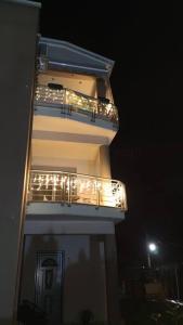 um edifício com uma varanda com luzes acesas à noite em Boutique lazou em Neochorópoulon