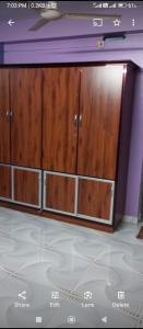 a tv with wooden cabinets in a room at MJ Nakksh in Port Blair