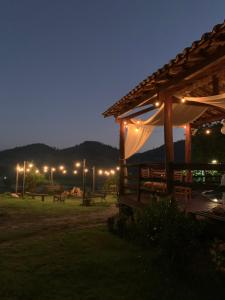 a wooden pavilion with benches and lights at night at Sítio Maranata Vale das Montanhas in Monte Alegre do Sul