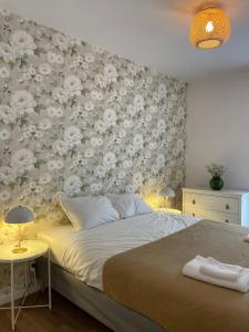 a bedroom with a bed with a floral wall at Trzy Sosny i Kurka in Ustroń