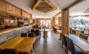 a dining room with wooden tables and chairs at Hotel Le Grand Tetras in Morzine