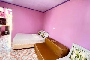 fioletowy pokój z łóżkiem i kanapą w obiekcie Einel Homestay 2 w mieście Siquijor