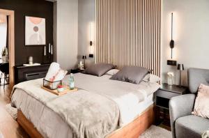- une chambre avec un grand lit et une chaise dans l'établissement Luxury and elegant apartment Madrid, à Madrid