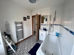 Baño blanco con bañera y lavamanos en Village Escape en Messingham
