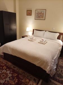 a bedroom with a large bed with two towels on it at Maison Christiana's in Kalavrita