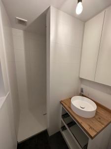 een witte badkamer met een wastafel en een spiegel bij Villa Naïla in Koksijde
