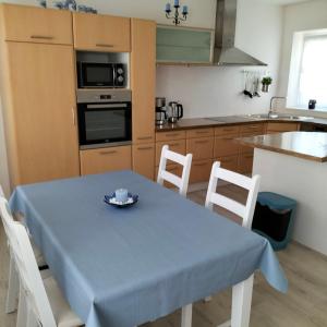 a kitchen with a table with a blue table cloth on it at neutal-ferienapartments in Neutal