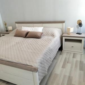 a bedroom with a white bed and two night stands at neutal-ferienapartments in Neutal