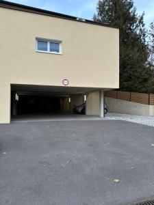 a building with a garage with a car in it at Harmony Living - 10 min to Graz in Lassnitzhöhe