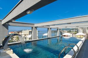 a swimming pool with a fountain on top of a building at Hotel La mer in Budva