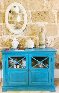a blue cabinet with a mirror on top of it at Picasso Art Room Studio Apartment in Alghero +130 photos