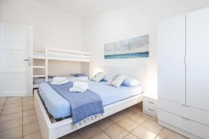 a bedroom with a white bed with towels on it at Moby Dick House in Villasimius +12 photos