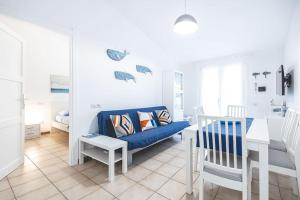 a living room with a blue couch and a table at Moby Dick House in Villasimius