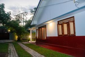 a house with a red and white facade at Dien Dee Stays in Hikkaduwa