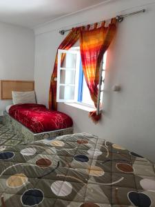 een slaapkamer met een bed en een raam bij Riad chez brahim in Essaouira