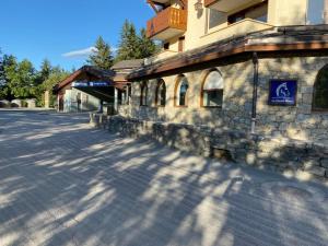 a street in front of a building with a handicapped sign at Appartement Le cheval Blanc VALMOREL 2ch 2sdb in Valmorel