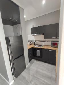 una cucina con mobili neri e un frigorifero in acciaio inossidabile di Blue Views Ocean at Brookes Hill Suites a Port Elizabeth Altre 19 foto