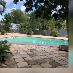 a swimming pool in a yard with a stone patio at Marandela Guesthouse in Louis Trichardt