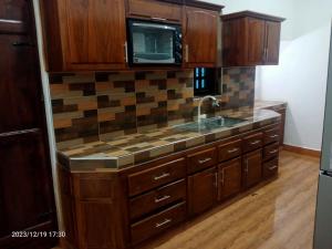 a kitchen with a sink and a microwave at Gunam Residence in Kattankudi