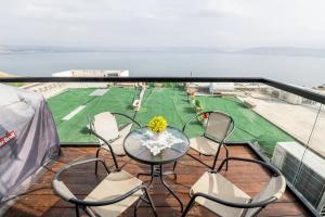 a balcony with a table and chairs and a field at Sea of Galilee Panorama Apartment by Sea N' Rent in Tiberias