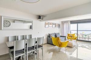 a living room with a table and yellow chairs at Sea of Galilee Panorama Apartment by Sea N' Rent in Tiberias