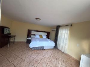 a bedroom with a large bed and a window at Marandela Guesthouse in Louis Trichardt