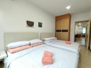 Duas camas num quarto com almofadas cor-de-rosa. em Eden 8pax 3Rooms apartment near Kuching Airport em Kuching