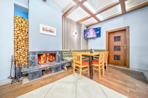 a dining room with a table and a fireplace at House Shiligarnika in Bansko