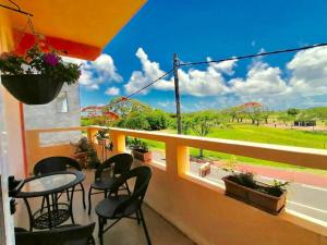 balcone con tavoli, sedie e vista su un campo di Sun & Earth Villa a Mont Choisy