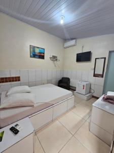 a bedroom with a large bed and a tv on the wall at Arahra Hotel in Aparecida de Goiânia