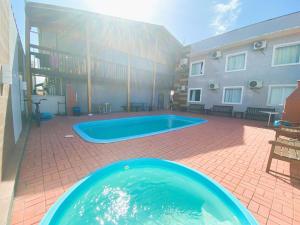 a large swimming pool in front of a building at CASA OLINDA - XXEstudio e SuitesXX wifi Ar split e Piscina in Porto Belo