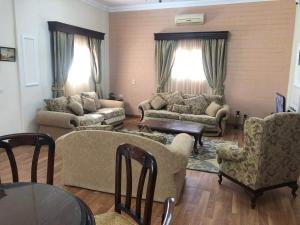 ein Wohnzimmer mit Sofas, Stühlen und einem Tisch in der Unterkunft Beautiful private villa Magawhish in Hurghada